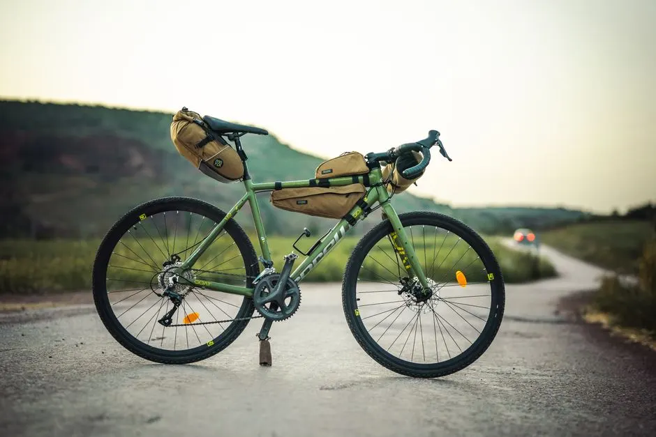 Un cyclotouriste installe sa propre selle sur un vélo de location, outils posés près de la roue arrière